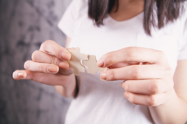 Femme tenant deux pièces de puzzle