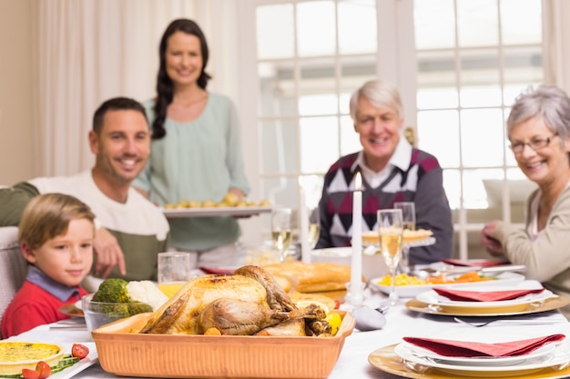 Femme tenant le dîner de Noël avec la famille à la table à manger