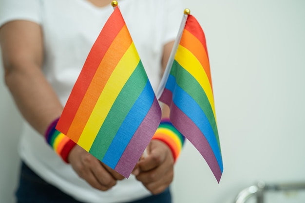 Femme tenant un drapeau coloré arc-en-ciel LGBT symbole de la tolérance et de la paix des droits de l'homme transgenres bisexuels gays lesbiennes