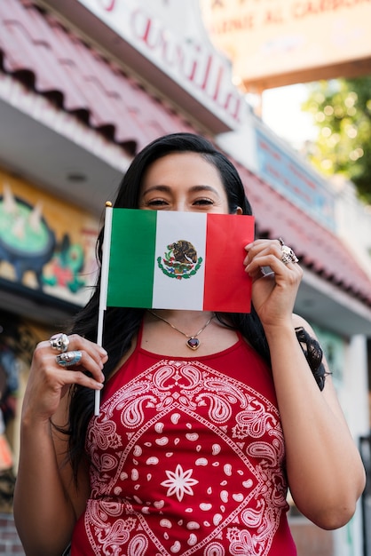 Femme tenant un drapeau mexicain dans la rue