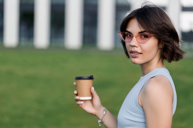 Femme tenant du café dans une tasse en papier