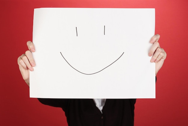 Femme tenant du papier avec sourire sur fond de couleur