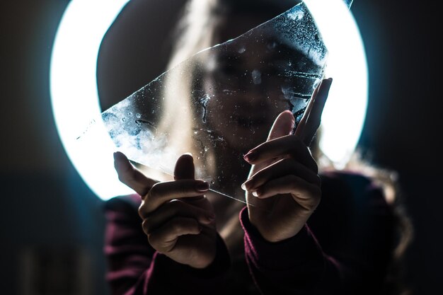 Photo femme tenant du verre sur le visage