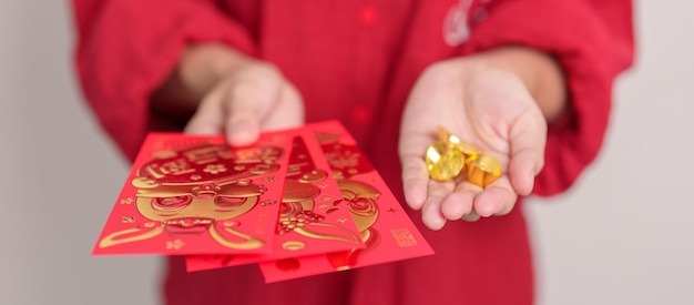 Femme tenant une enveloppe rouge chinoise avec un cadeau d'argent en lingots d'or pour les vacances du Nouvel An lunaire heureux La phrase chinoise signifie le bonheur en bonne santé Lucky and Wealthy