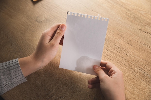 Femme tenant une feuille de papier vierge