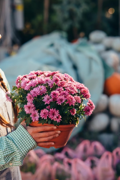 Femme tenant une fleur décorative en pot de fleurs sur le marché