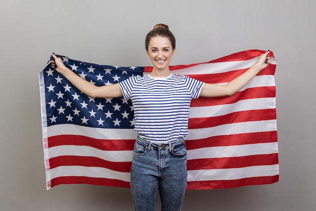 Femme tenant un grand drapeau américain exprimant des émotions positives et du bonheur