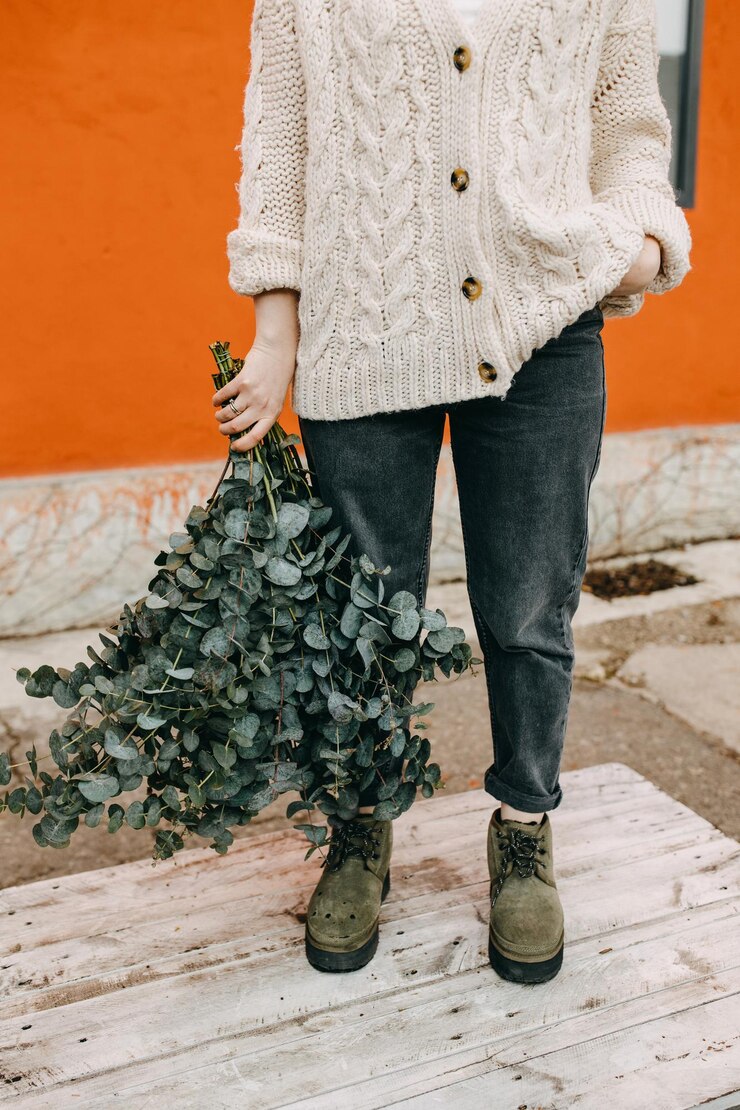 Femme tenant un gros bouquet de branches d'eucalyptus