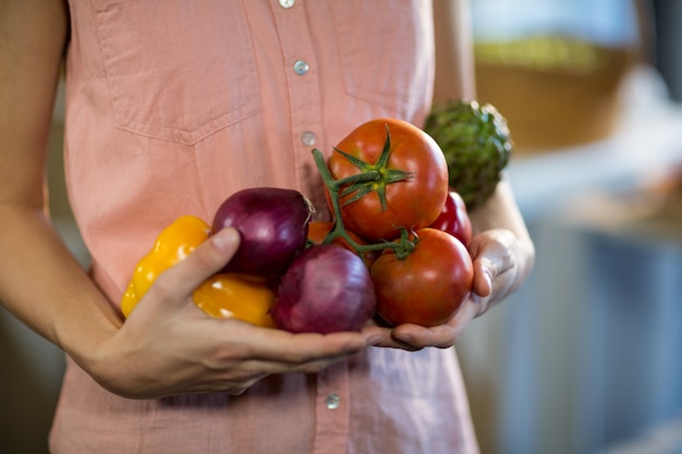 Femme tenant des légumes à l'épicerie