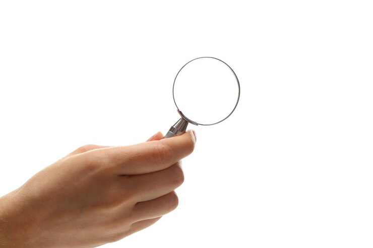 Photo femme tenant une loupe sur fond blanc gros plan