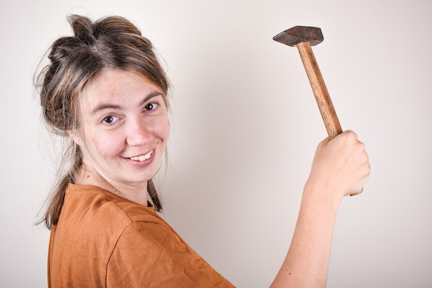Femme tenant un marteau pour la rénovation de la maison