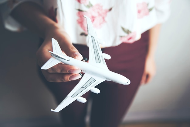 Femme tenant un modèle d'avion à la main