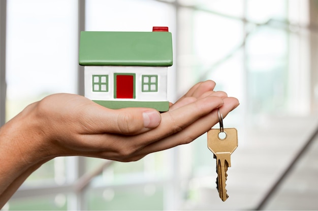 Femme tenant le modèle et la clé de la petite maison