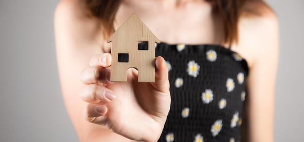 Femme tenant un modèle de maison