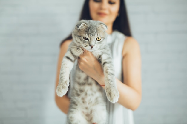 Femme tenant et montrant le chat