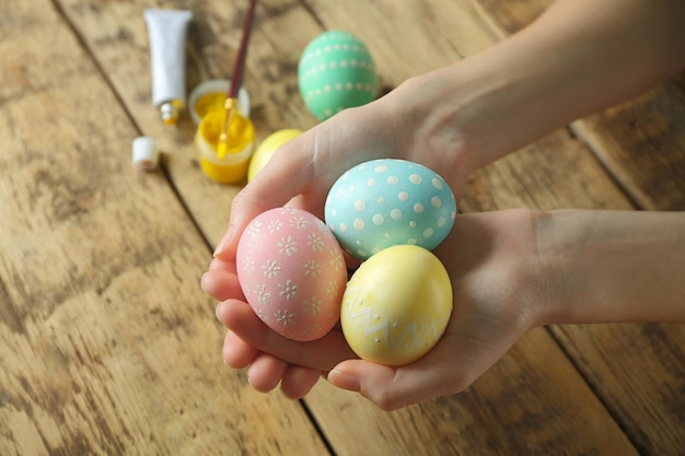 Femme tenant des oeufs de Pâques sur fond de bois