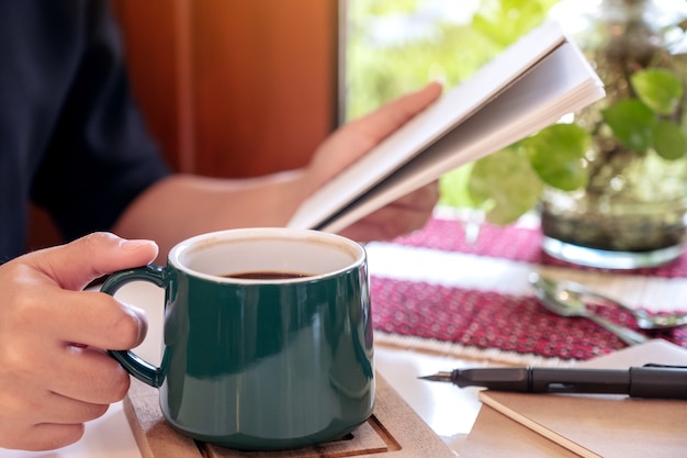 Une femme tenant un ordinateur portable en buvant du café