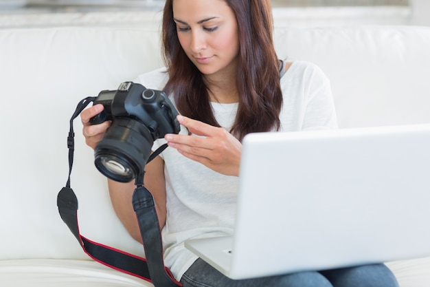 Femme tenant un ordinateur portable et une caméra