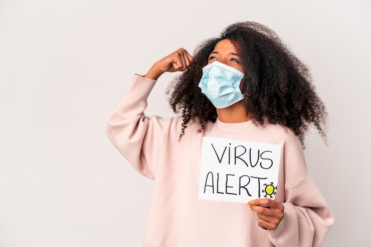 Photo femme tenant une pancarte d'alerte au virus levant le poing après une victoire