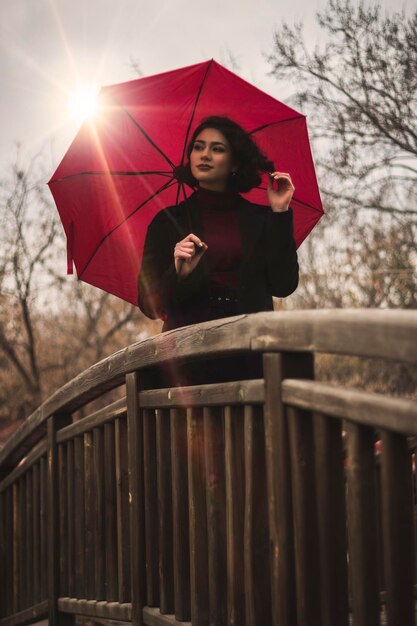 Photo une femme tenant un parapluie debout contre le ciel