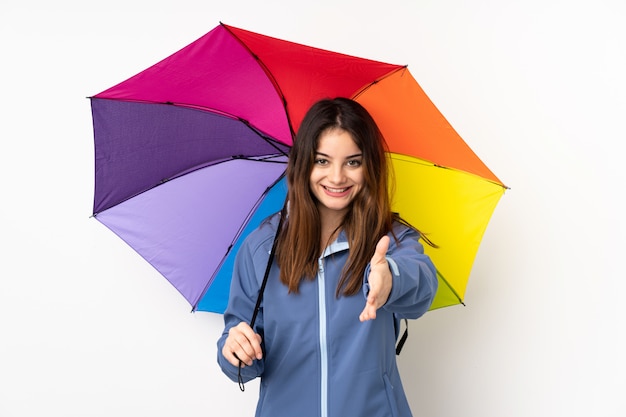 Femme tenant un parapluie isolé sur le mur blanc poignée de main après une bonne affaire