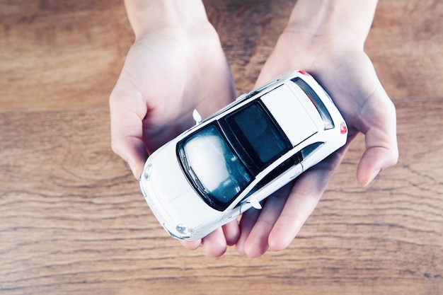 femme tenant une petite voiture dans ses mains