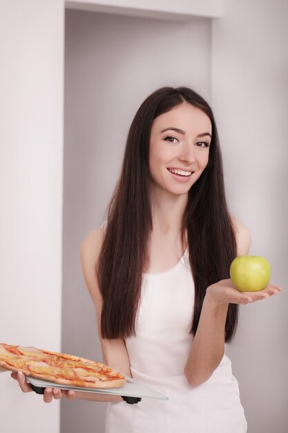 Femme tenant une pizza.