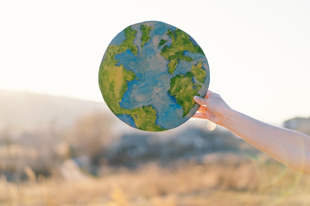 Femme tenant la planète dans les mains sur fond de printemps vert jour de la terre