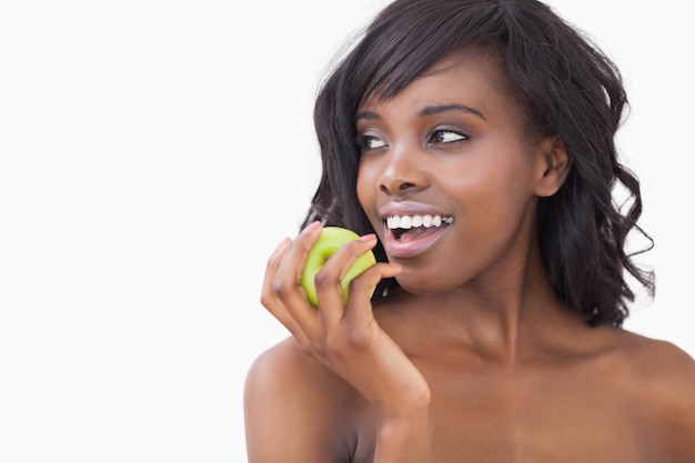 Femme tenant une pomme en souriant