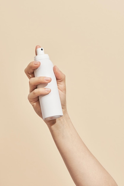Femme tenant un produit cosmétique à la main