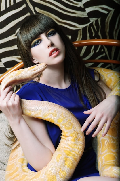 femme tenant un python jaune