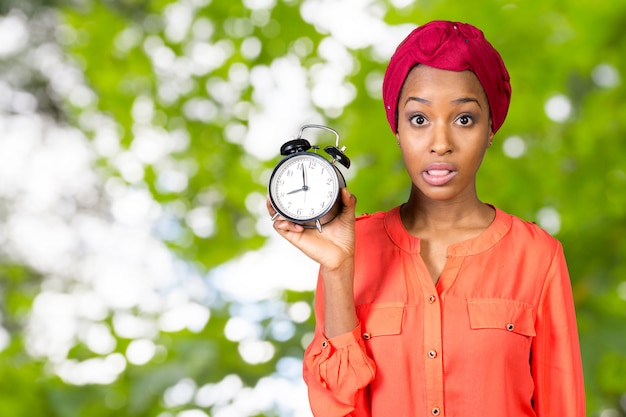 femme tenant, regardant anxieusement une horloge