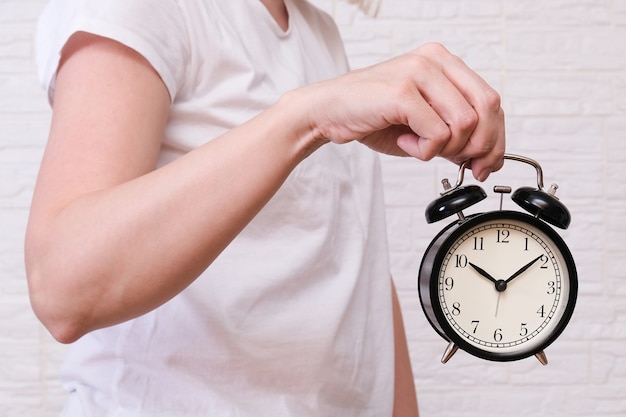 Photo femme tenant un réveil indiquant 10 heures, les gens doivent apprécier et apprécier le temps, le concept de délai.