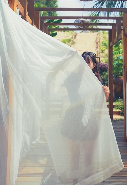 Photo femme tenant un rideau alors qu'elle se tient dans le parc