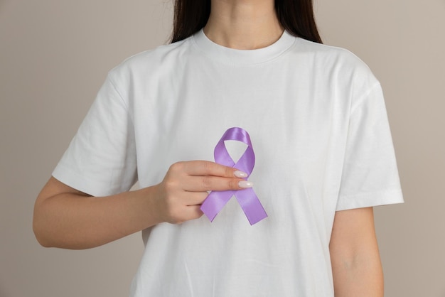 Femme tenant un ruban violet dans ses mains ADDADHDMaladie d'Alzheimer Malformation d'Arnold ChiariEnfance Hémiplégie AVC Épilepsie Douleur aiguë chroniqueCrohns