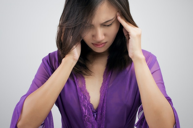 femme tenant sa tête avec les mains car a des maux de tête