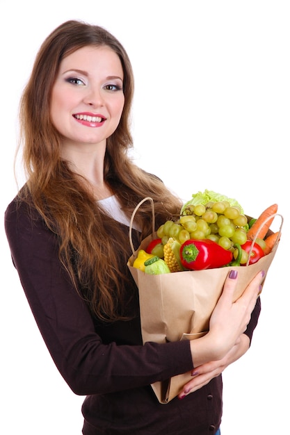 Femme tenant un sac d'épicerie plein de fruits et légumes frais isolés sur blanc