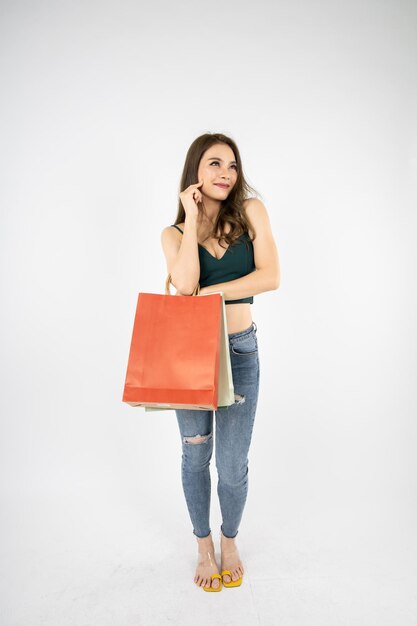 Femme tenant des sacs en papier sur fond blanc