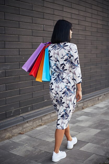 Femme tenant des sacs en papier marchant dans la rue