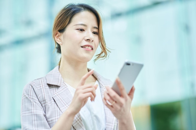 Femme tenant un smartphone à l'extérieur