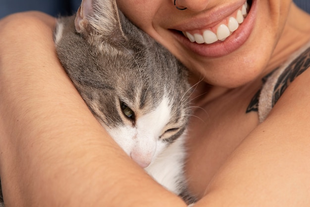 Photo femme tenant son adorable minou à l'intérieur