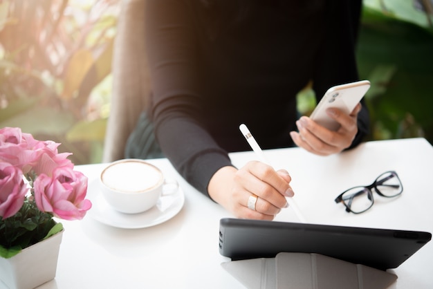 Femme tenant un stylo sur l'application de CV avec un téléphone intelligent et à l'aide d'une tablette pour la recherche d'emploi sur Internet en ligne. postuler pour un concept d'emploi.