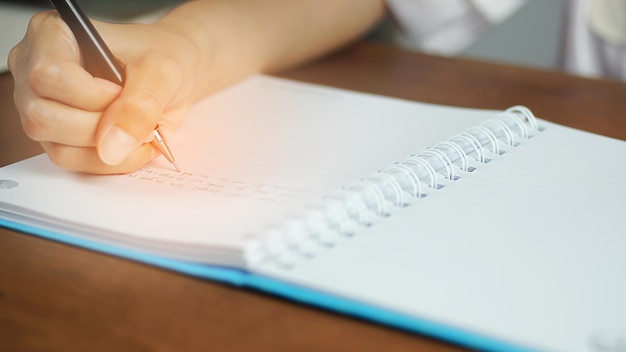 une femme tenant un stylo et écrivant