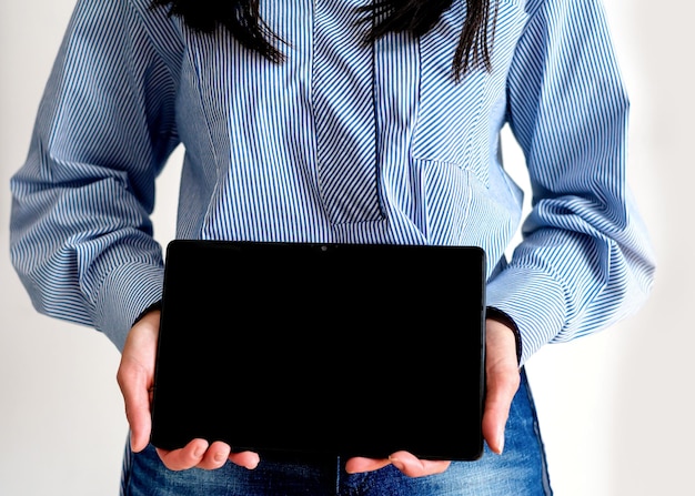 Photo une femme tenant une tablette dans ses mains