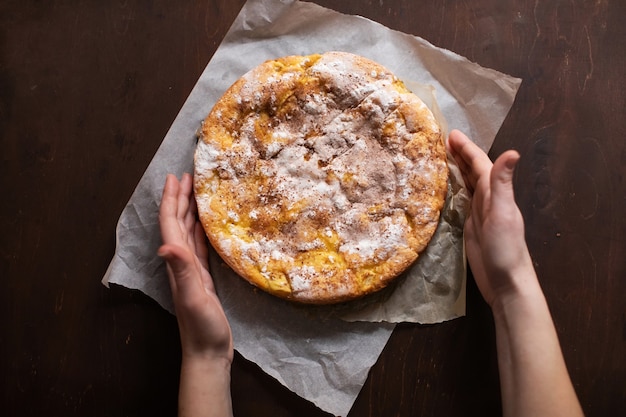 Femme tenant une tarte aux pommes maison dans ses mains