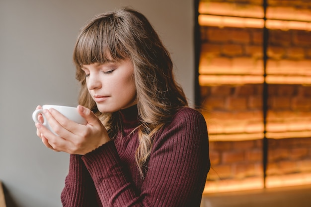 La femme tenant une tasse au restaurant