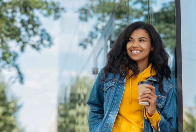 femme tenant une tasse de café à emporter