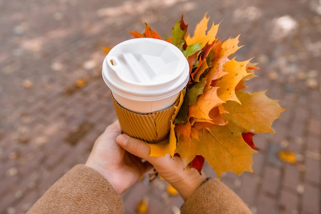 Femme tenant une tasse de café pour aller en automne automne