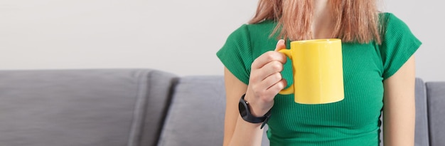 Femme tenant une tasse de café ou de thé