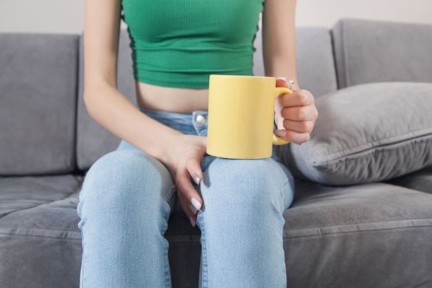 Femme tenant une tasse de café ou de thé.